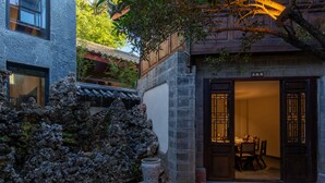 Un edificio tradicional con pared de piedra, puerta de madera y suelo de baldosas.