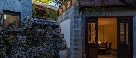 A traditional building with a stone wall, a wooden door, and a tiled floor.