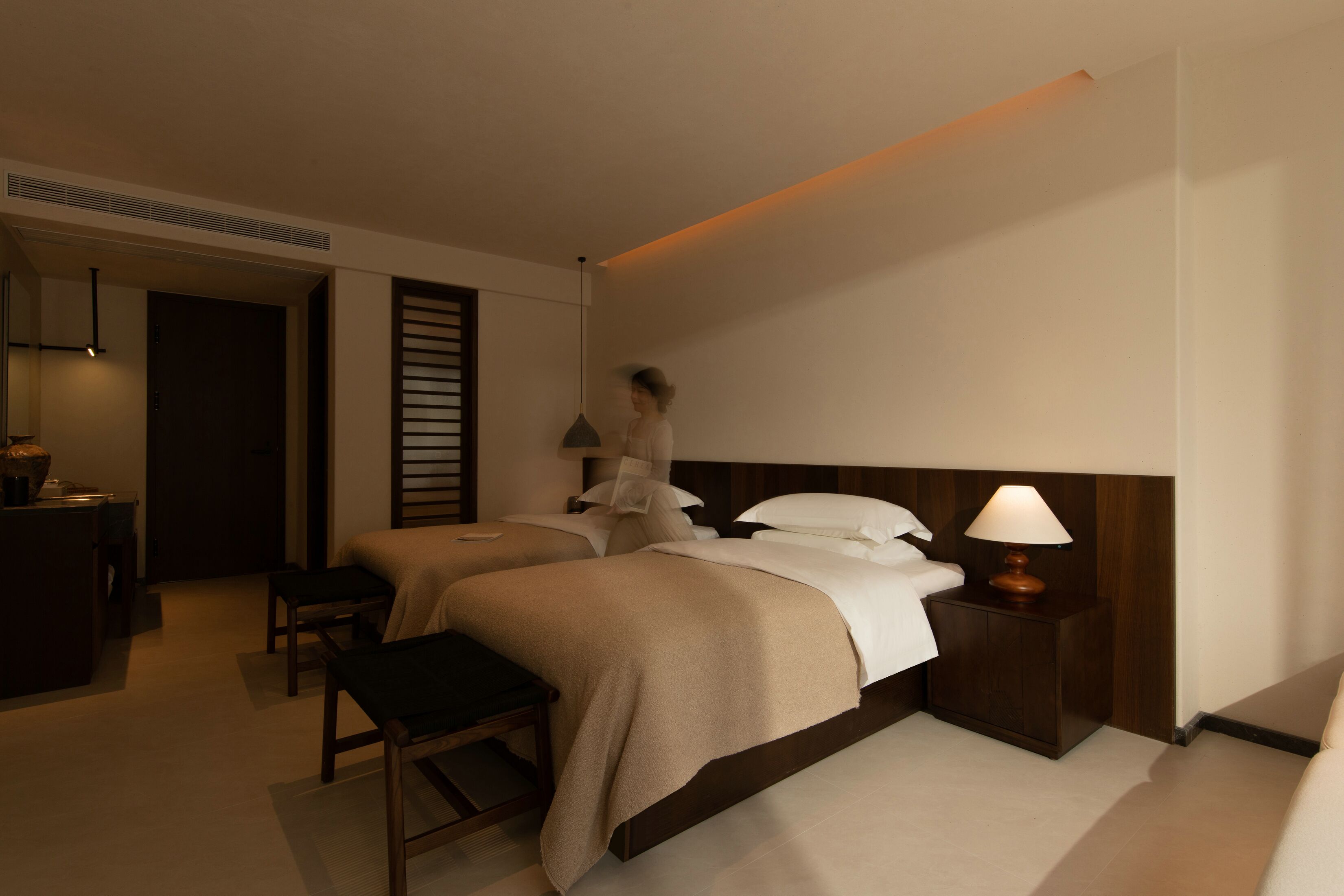 Una habitación de hotel con dos camas, un escritorio y una silla.