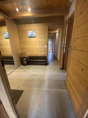 Passadís amb parets de fusta i una panxa, que condueix a una porta.