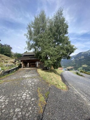 A traditional building with a stone pathway leading to it, surrounded by trees and a mountainous landscape. - CHALET HAUT 6 - HAUTELUCE LES SAISIES (HAUTELUCE LES SAISIES)