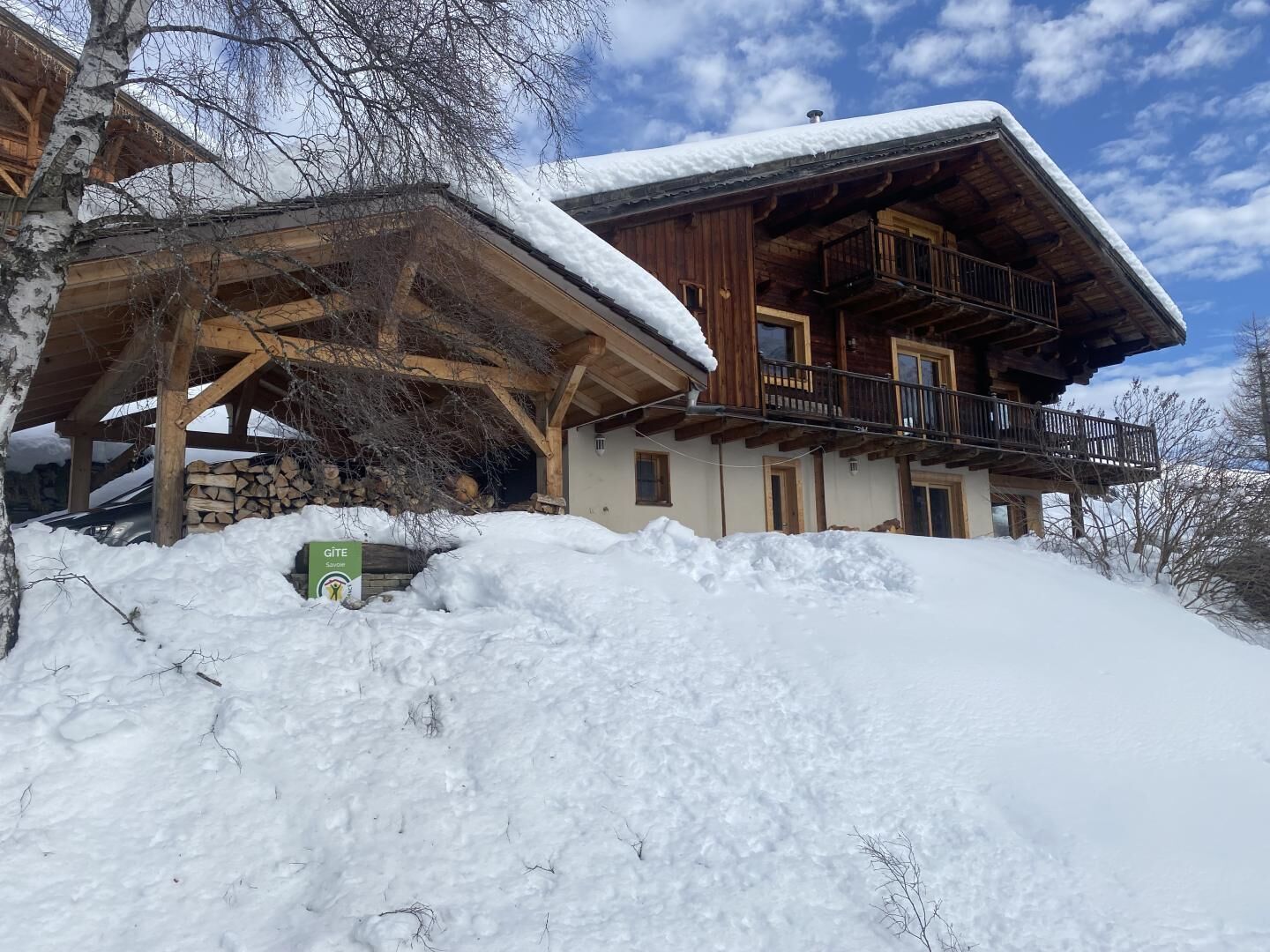 A wooden chalet with a balcony, surrounded by snow.