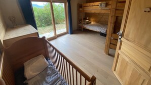 Une cabine équipée d’un lit superposé, d’un bureau en bois et d’une grande fenêtre.