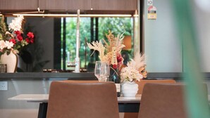Una cocina moderna con una mesa de comedor lista para dos personas, con un florero de flores y una botella de champán.