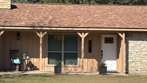 A building with a brick roof, a stone wall on one side, and a door with the number 5531. There are two potted plants in front of the door. - Welcoming 6-bedroom house with country living in the shadow of Kyle Field (College Station)