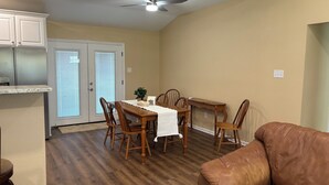 A dining area with a wooden table, chairs, and a ceiling fan. - Welcoming 6-bedroom house with country living in the shadow of Kyle Field (College Station)