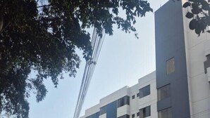 Un edificio moderno con fachada azul y blanca, varios pisos y una entrada visible con un letrero.
