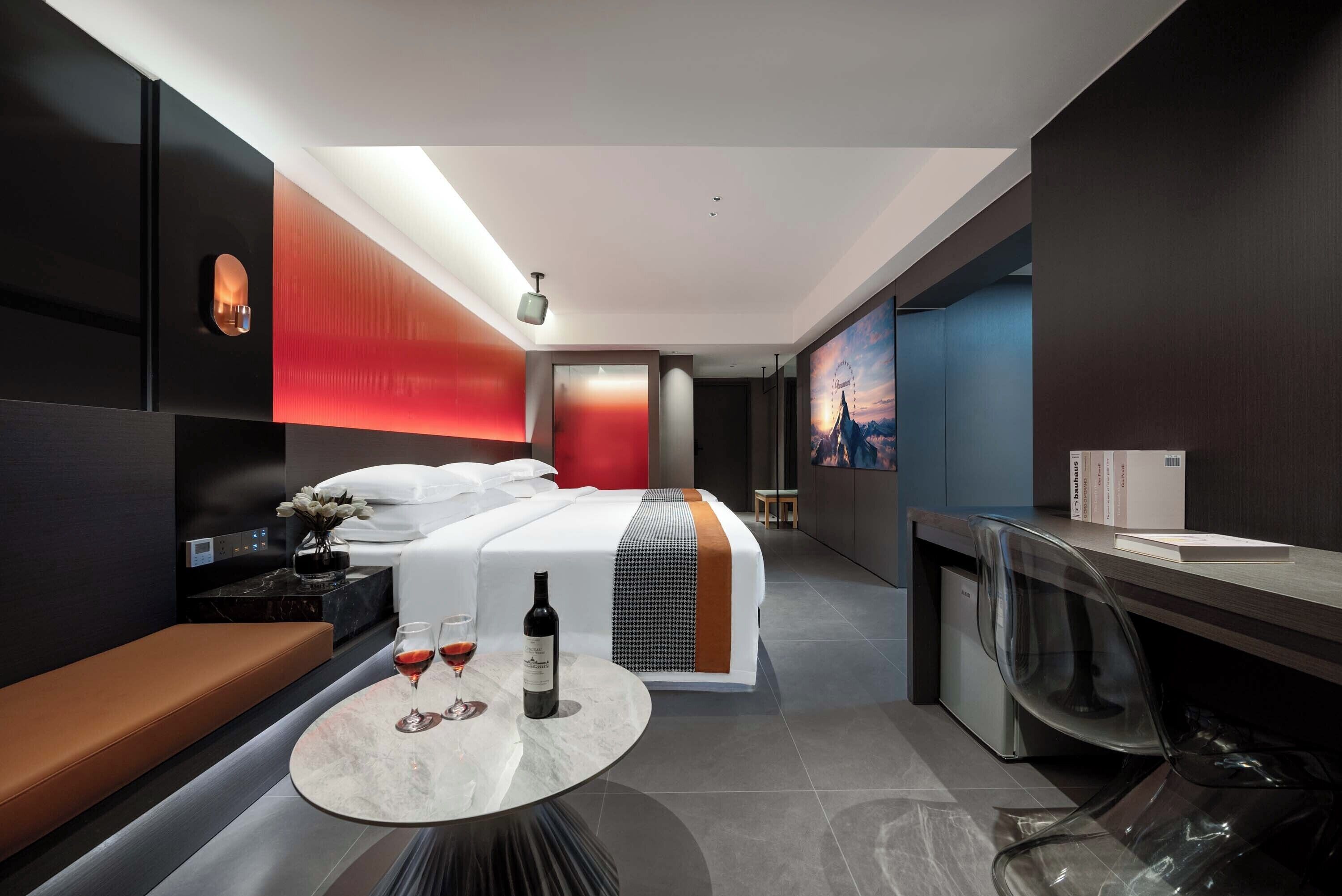 Une chambre d’hôtel moderne équipée d’un lit, d’une table de chevet et d’un coin salon avec une table.