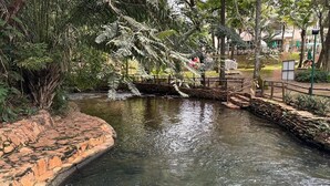 Un fiume tranquillo con un ponte in pietra circondato da una vegetazione lussureggiante.