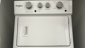 A Whirlpool washer with multiple control knobs for different wash settings.