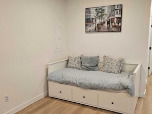 A bedroom with a bed, a wall-mounted painting, and a door. - Modern Suite in Willoughby Langley Private Entry Full Kitchen Fast WiFi (Langley Township)