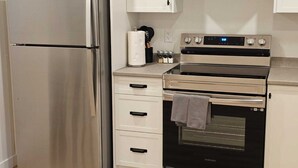 A kitchen with a stainless steel refrigerator, a built-in oven, and a microwave.
