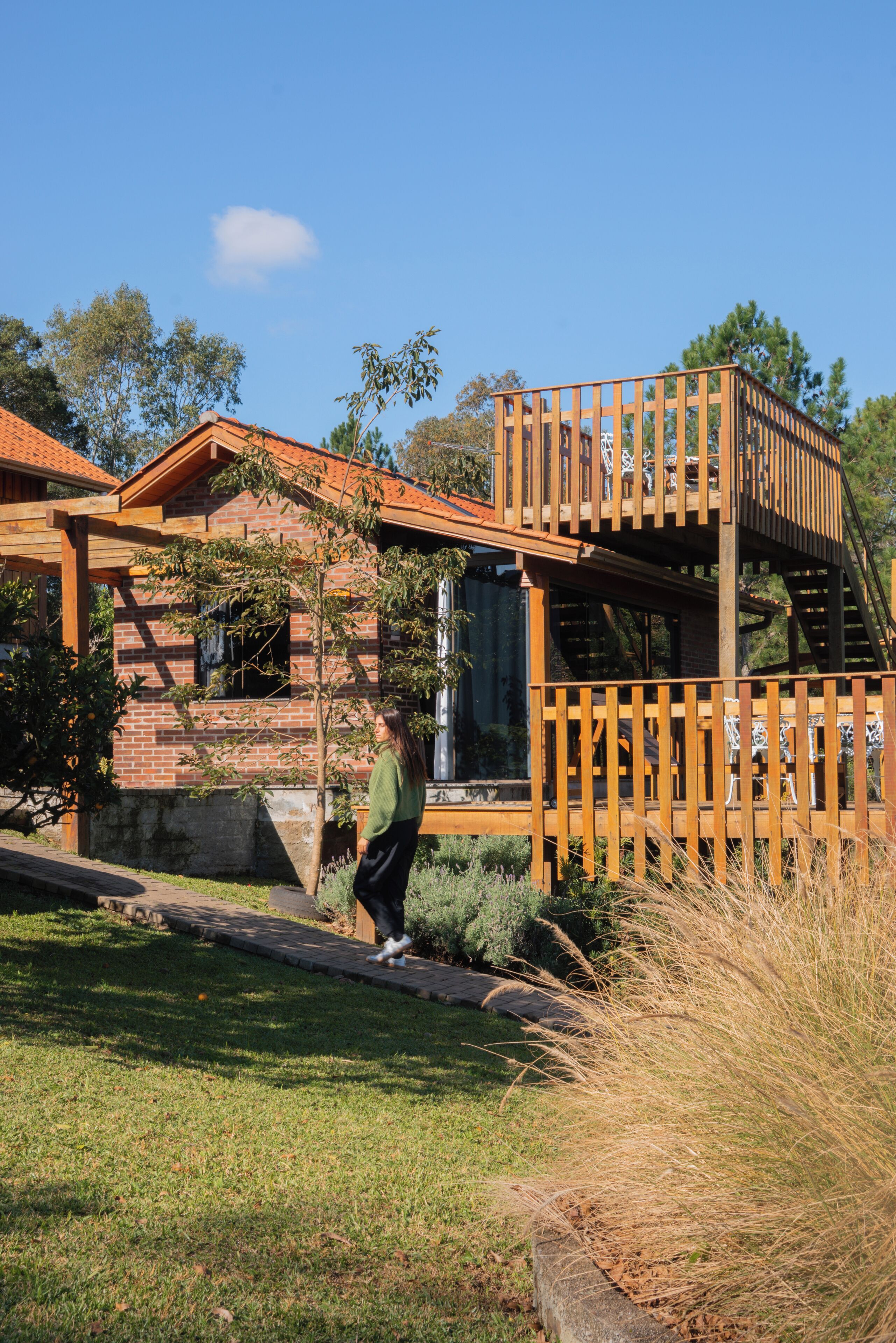 Una casa moderna con terraza de madera y fachada de ladrillo.