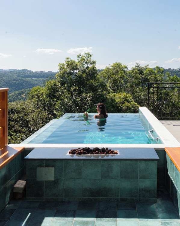 A swimming pool with a view of a forested landscape.