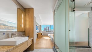 Een moderne badkamer met een grote wastafel, een houten opbergmeubel en een douchecabine met glazen wanden.