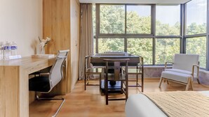 Een moderne kamer met een houten bureau, een computer, een stoel en een bed.
