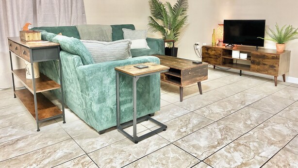A living room with a sofa, coffee table, TV stand, and potted plants.