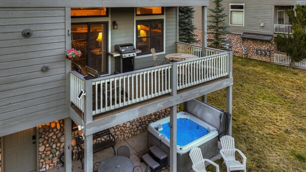 Een herenhuis met een balkon, buitenmeubels en een jacuzzi.