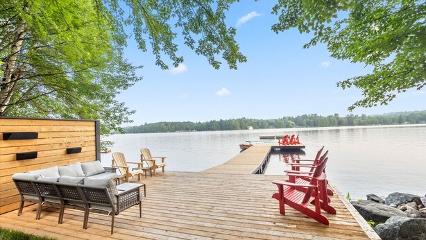 A wooden deck with outdoor furniture and a view of a lake. - Cedar Sauna, Cedar Hot Tub, Lakeside Fire Pit, Private Beach | La Dolce Muskoka (Bracebridge)