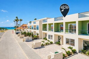 A hotel with multiple floors, balconies, and a view of the beach.