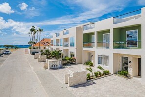 Un hotel moderno con piscina, asientos al aire libre y vista al océano.