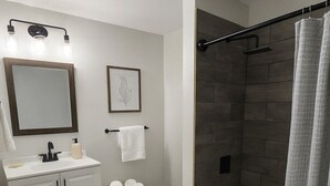 Een moderne badkamer met toilet, wastafel en bad.