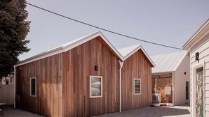 A modern wooden building with a sloped roof and two small windows. - The Old Woolstore (Northern Midlands)