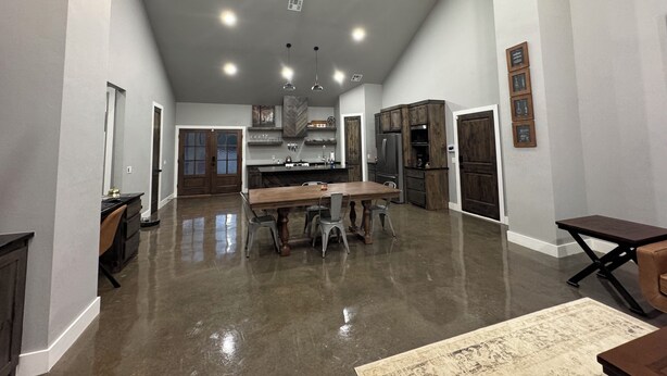 A spacious kitchen with a central island, dark wooden cabinets, and a ceiling fan.