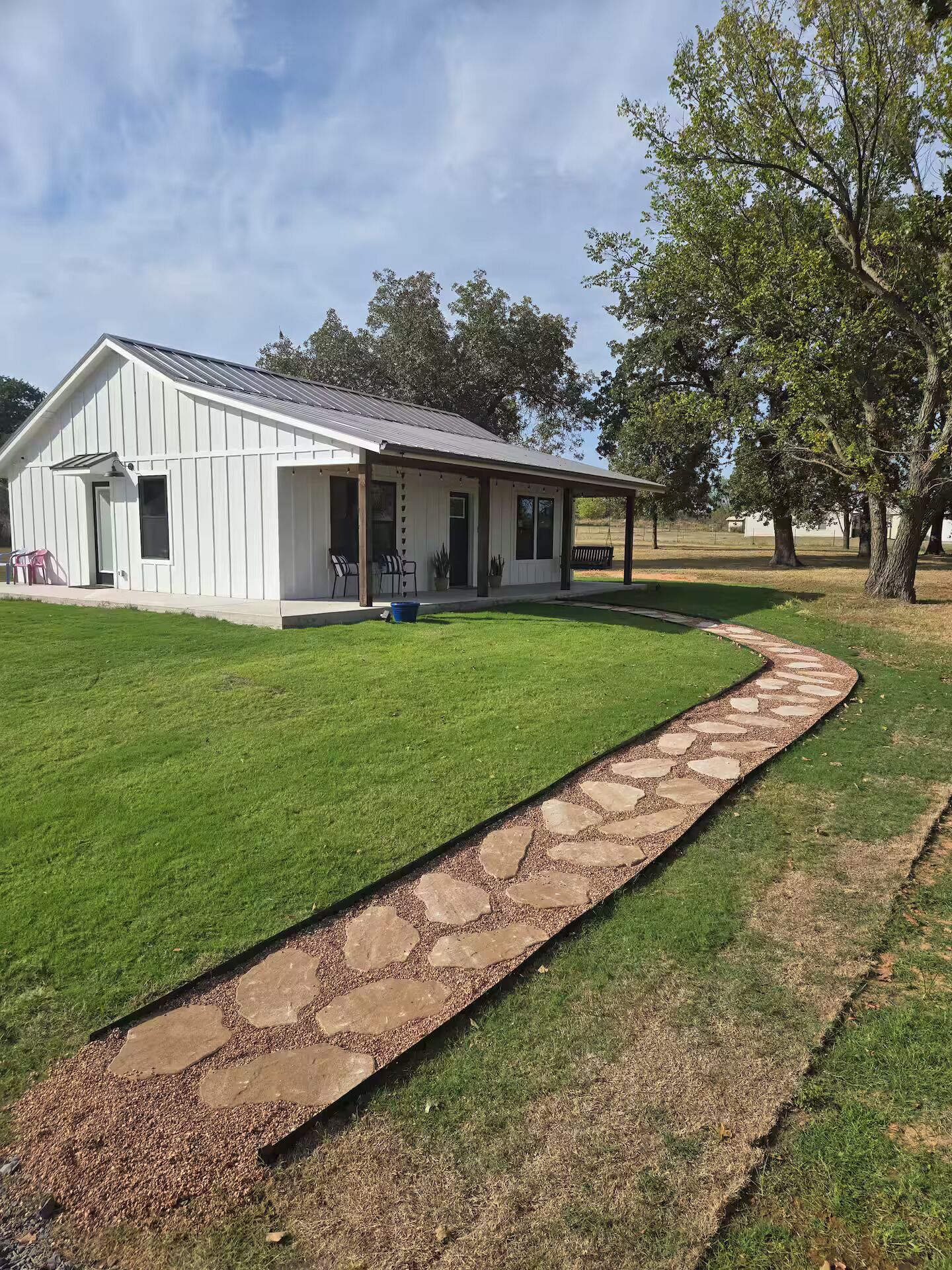 Pea gravel walkway with paving stones leads you to the front door.