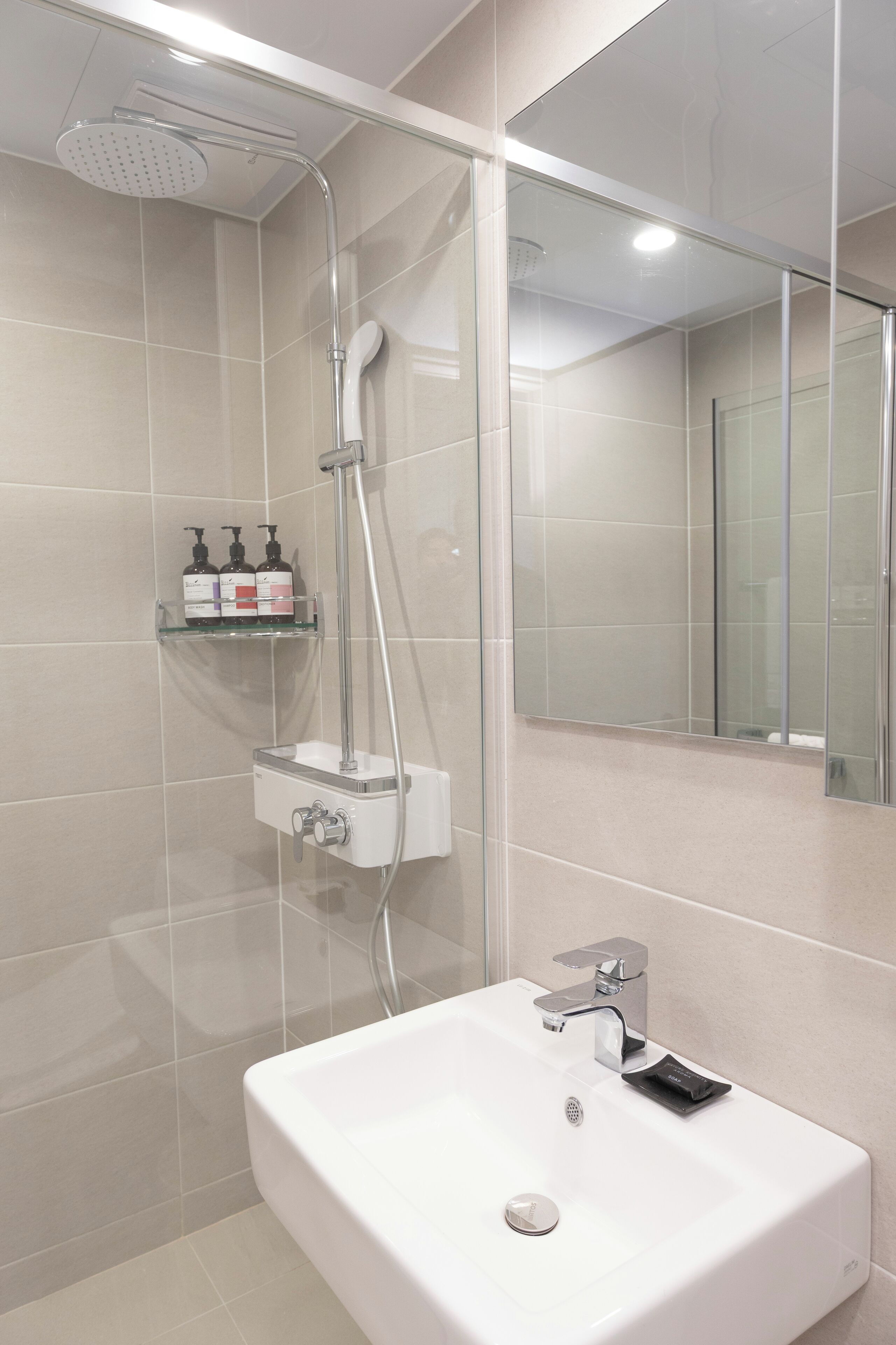 Ein modernes Badezimmer mit Dusche, Waschbecken und einer Duschkabine aus Glas.