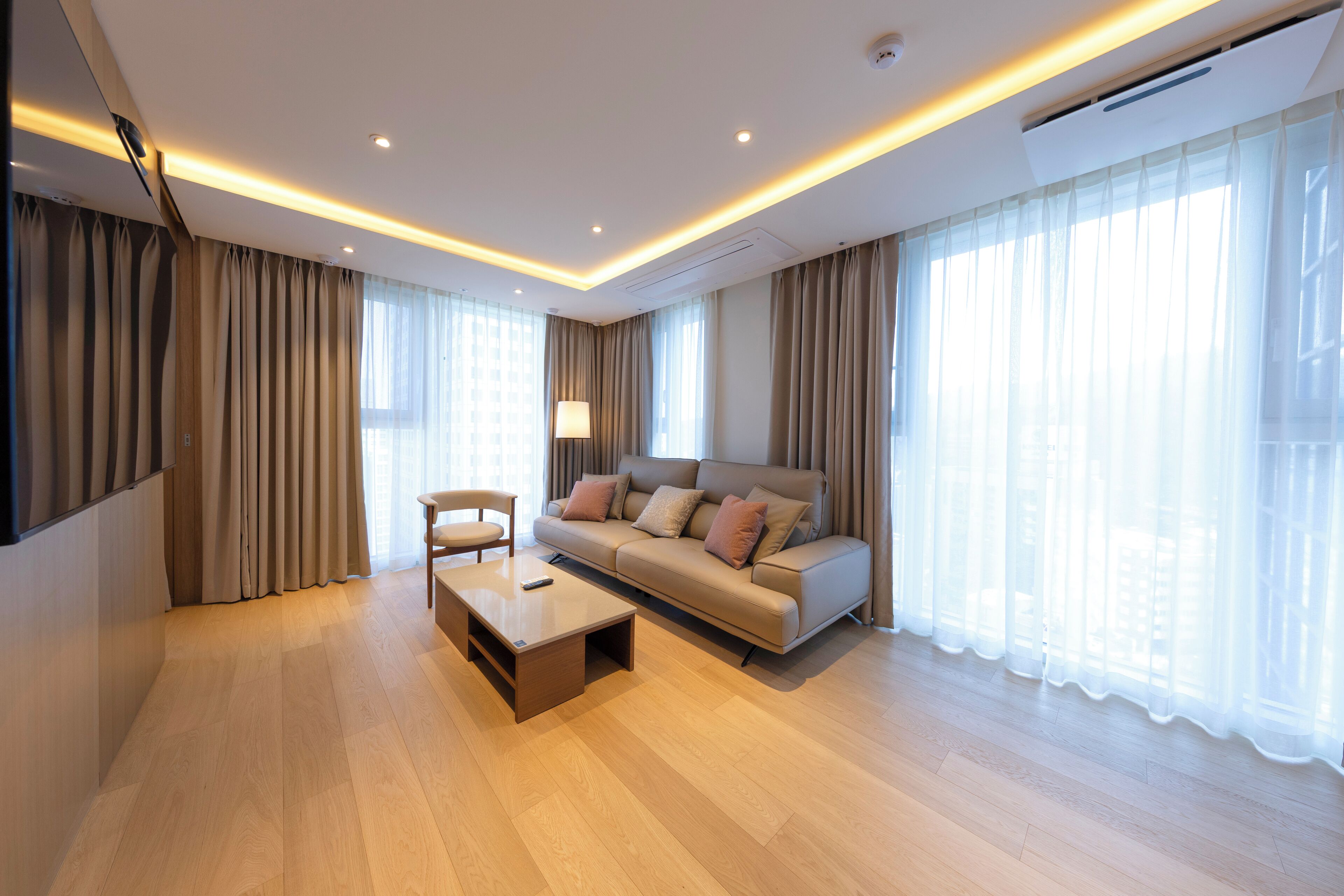 A modern living room with a sofa, a coffee table, and a TV.