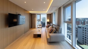 A modern hotel room with a large window, a sofa, a flat-screen TV, and a wooden floor. - SL Hotel Myeongdong (Seoul)