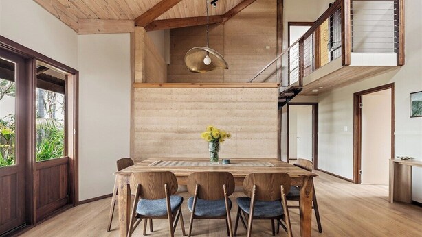 A dining area with a wooden table and chairs, a hanging light fixture, and a view of the outdoors. - Pepperstone—Serene Coastal Hideaway with Fire Pit (Dunsborough)