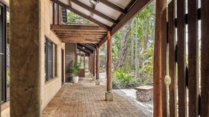 A covered walkway with a brick floor, wooden pillars, and potted plants. - Pepperstone—Serene Coastal Hideaway with Fire Pit (Dunsborough)