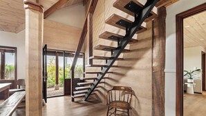 A staircase with a wooden finish and metal railings, leading to an open area with a bench and a chair. - Pepperstone—Serene Coastal Hideaway with Fire Pit (Dunsborough)