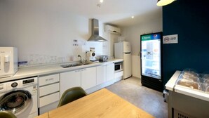A compact kitchenette with a microwave, toaster, and a refrigerator. - NU Hotel (Cheonan)