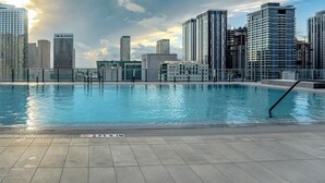 Una piscina en la azotea con un horizonte urbano al fondo.