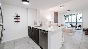 Una cocina moderna con isla central, lavavajillas integrado y espacio para vinos.