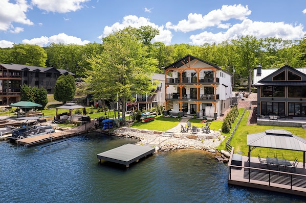 A lakeside hotel with a dock, outdoor seating, and a well-maintained lawn.