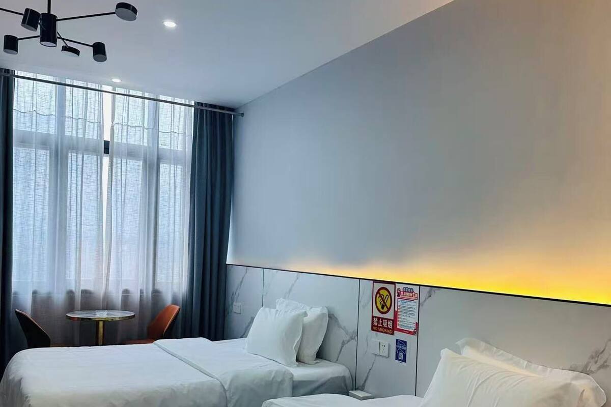 Une chambre d’hôtel avec deux lits, une table ronde et une chaise.