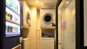 A compact laundry room with a washing machine, dryer, and a vending machine offering beverages. - HOTEL LiVEMAX Nara Ekimae (Nara)