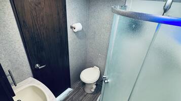 Een douche, handdoeken, toiletpapier