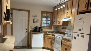 A kitchen with wooden cabinets, a dishwasher, a stove, and a refrigerator. - Privacy & nature with Hot Tub, Fireplace, fire pit, & local outdoor activities, (Mount Lookout)