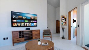 A modern living room with a flat-screen TV mounted on the wall displaying various streaming services. - Panoramic Paradise Above Puerto Vallarta. Infinity Pool over Romantic Zone
 (Puerto Vallarta)