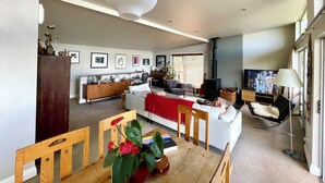 A modern living room with a sofa, dining table, and a fireplace.