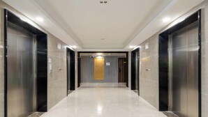A modern hallway with elevators and a door at the end. - Wonderful Beginning (Tai'an)