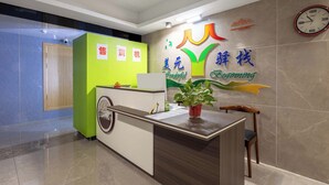 A reception desk with a green and white color scheme, a clock on the wall, and a potted plant on the counter. - Wonderful Beginning (Tai'an)