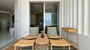 A balcony with wicker furniture, a view of the interior, and a sliding glass door. - Seaview 2beds in the heart of HuaHin BP2 (Hua Hin)