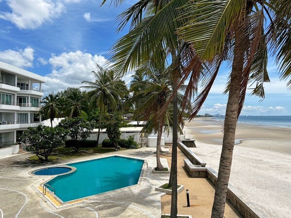 A resort with a swimming pool, palm trees, and a beach view. - Seaview 2beds in the heart of HuaHin BP2 (Hua Hin)