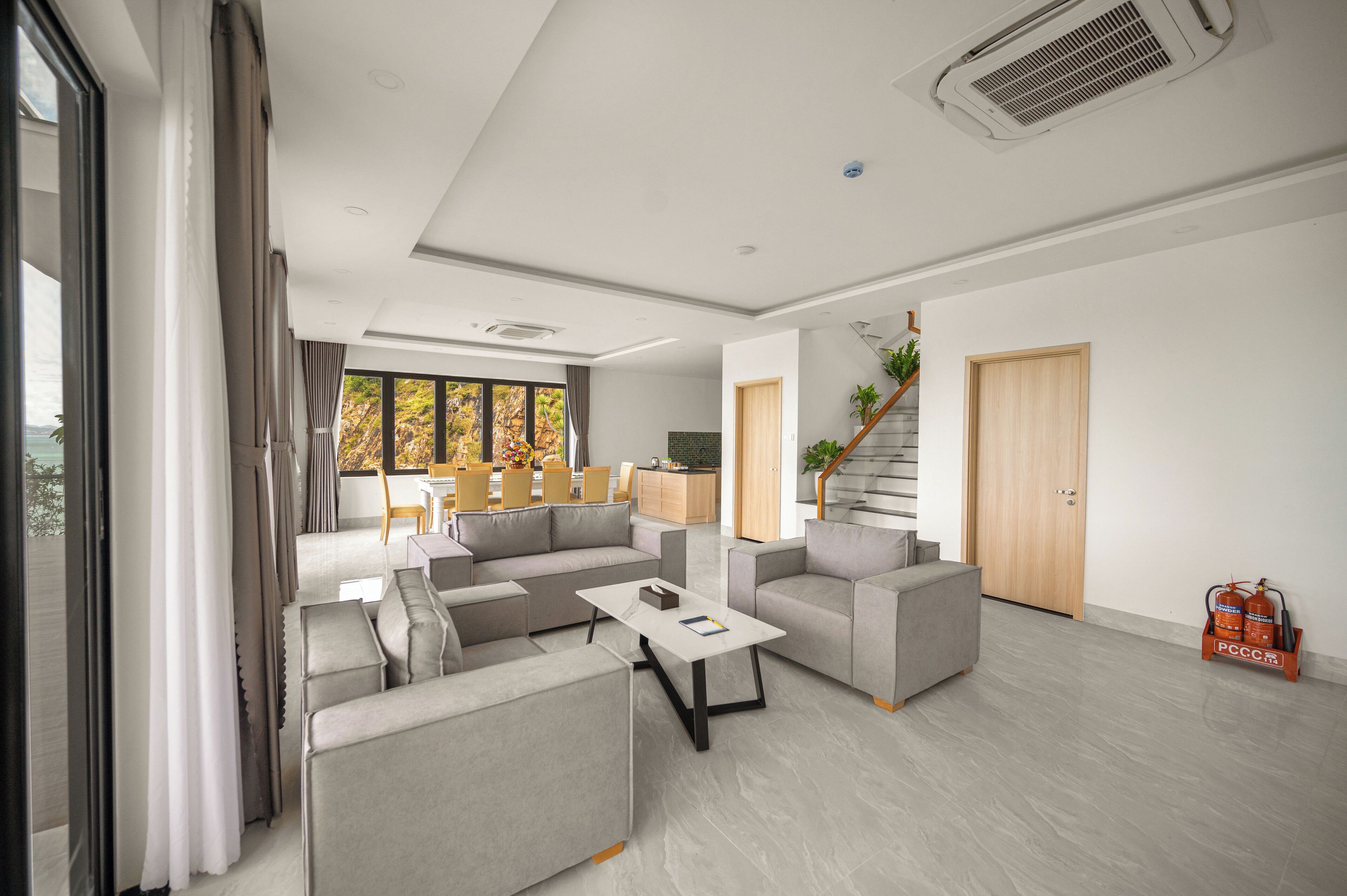 Ein modernes Wohnzimmer mit einer Sofagarnitur, einem Couchtisch und einer Treppe zu einer weiteren Ebene.